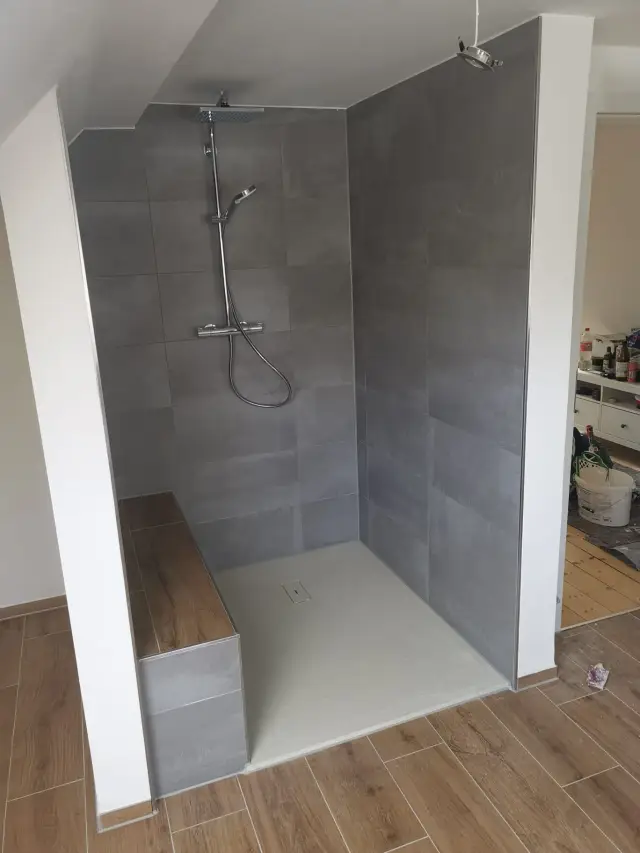 Prysznic z szarymi płytkami, ławką z płytki drewnopodobnej i termostatyczną baterią